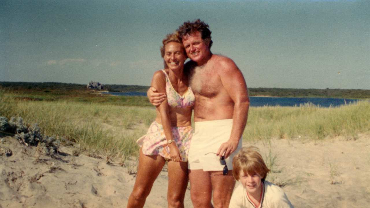 a man, woman and a child at the beach